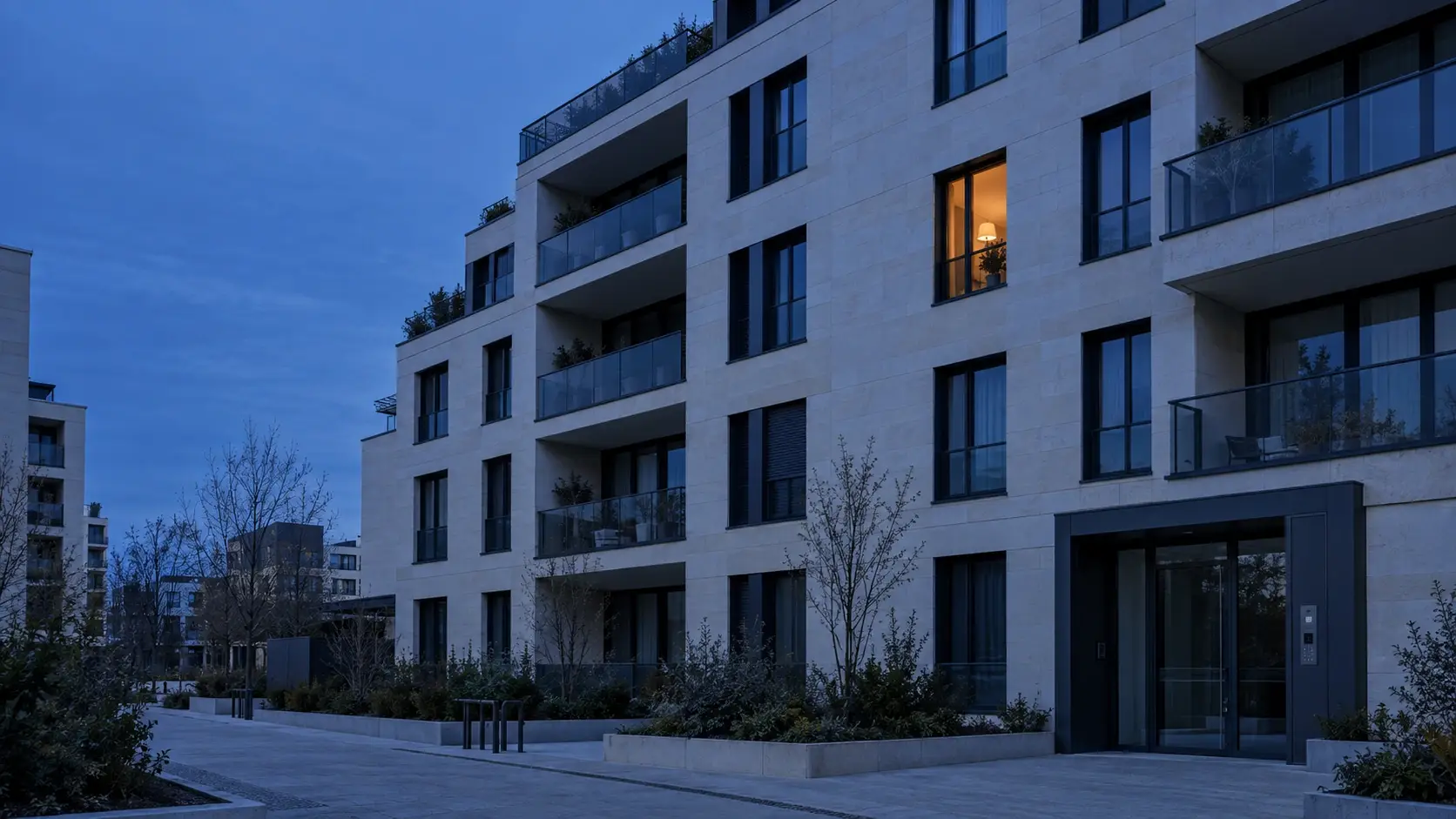 Immeuble résidentiel contemporain français au crépuscule, façade bleu nuit et fenêtre éclairée